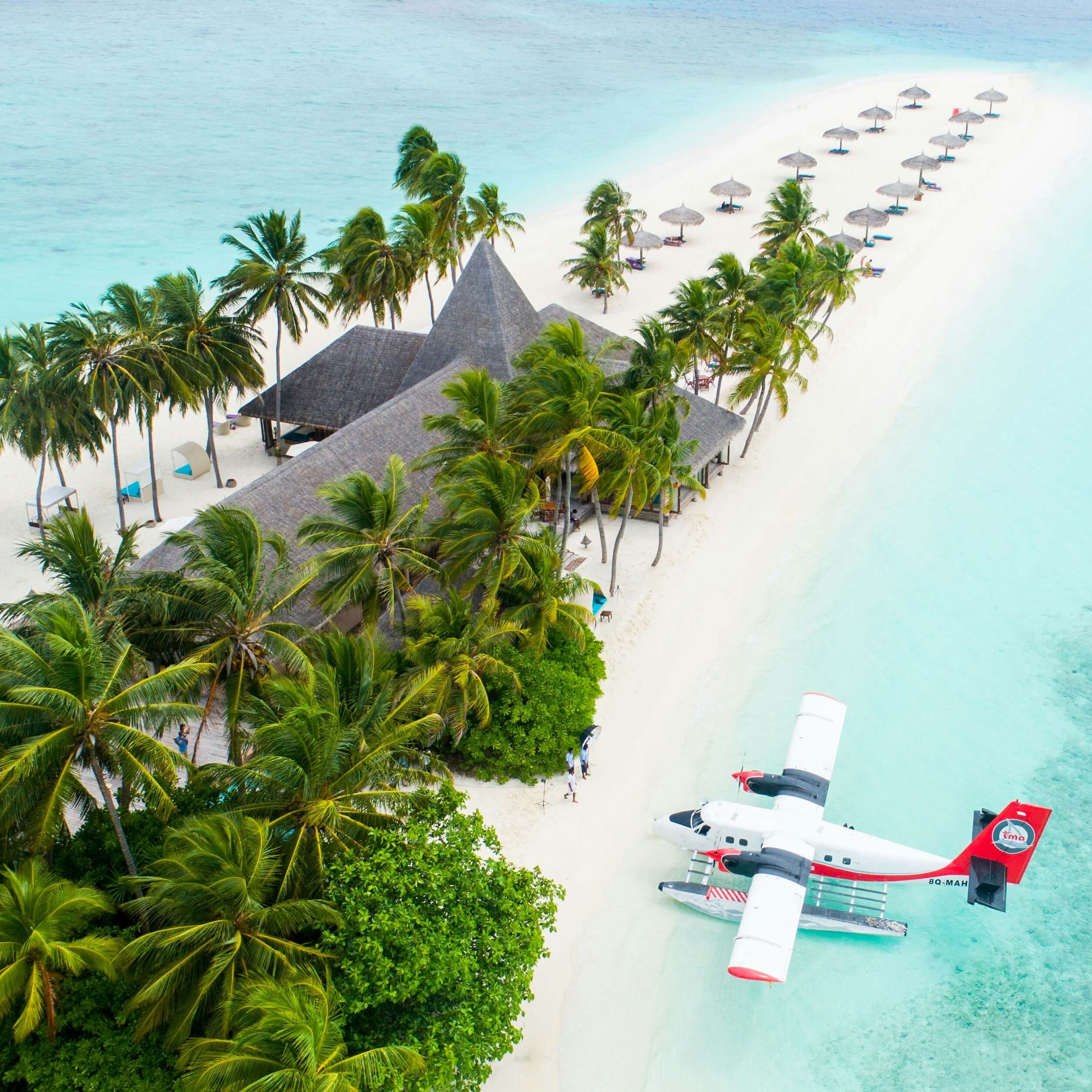A TMA seaplane parked on a Maldives beach, illustrating the seaplane transfer that connects most resorts to Malé
