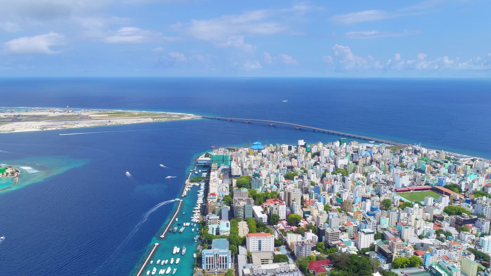 Aerial view of Malé, the densely built Maldivian capital, ringed by sea with the bridge to the airport island