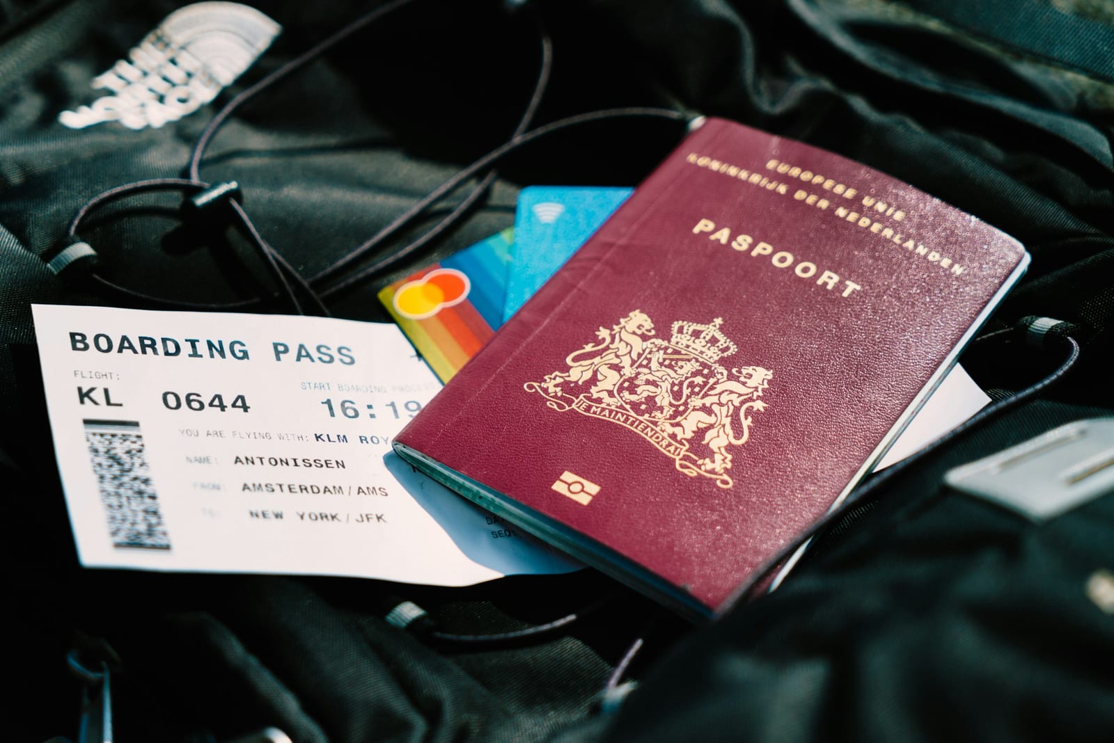 A passport and an airline boarding pass resting on a travel bag
