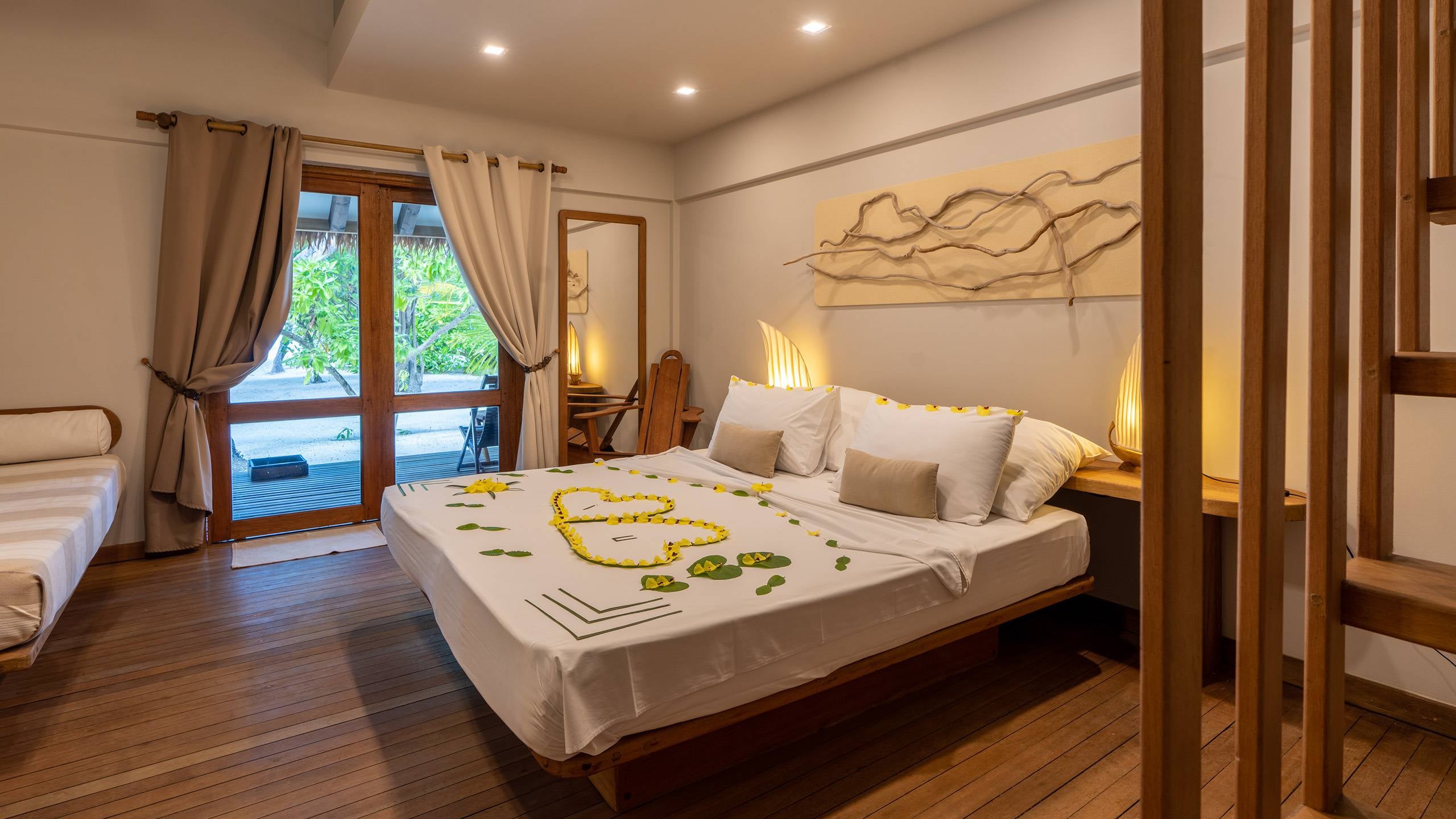 Beach Bungalow im Alimatha Aquatic Resort, ein Bungalow mit Satteldach direkt am Korallensandstrand der Insel