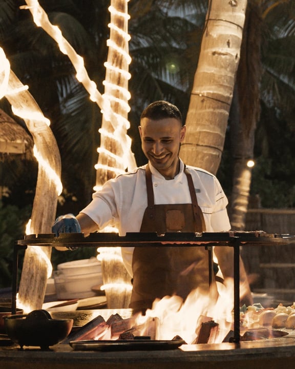 Foto di Baglioni Maldives Luxury All-Inclusive del 14 settembre 2026. Potrebbe essere un'immagine raffigurante fuoco, ristorante grill, grembiule, cucina e testo.