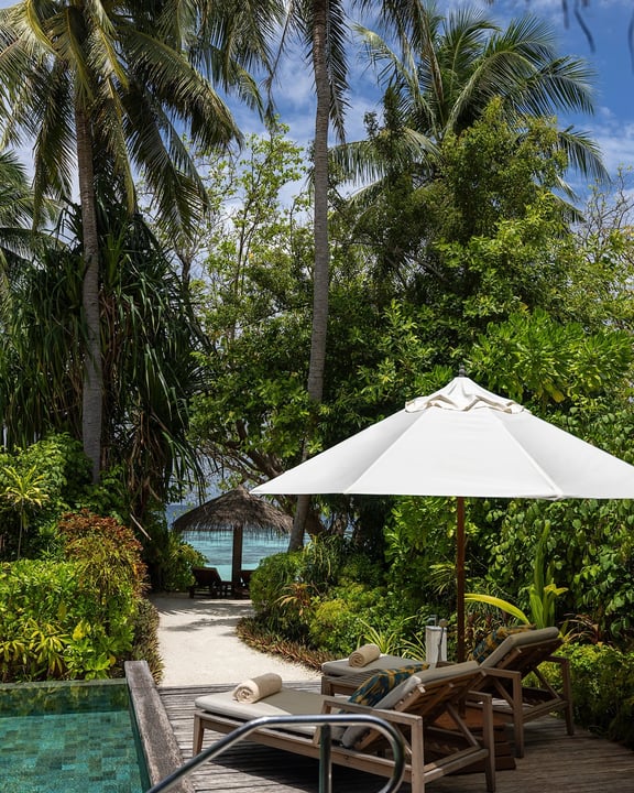 Photo by Baros Maldives on August 07, 2026. May be an image of chaise longue, umbrella, cabana, palm trees and text.