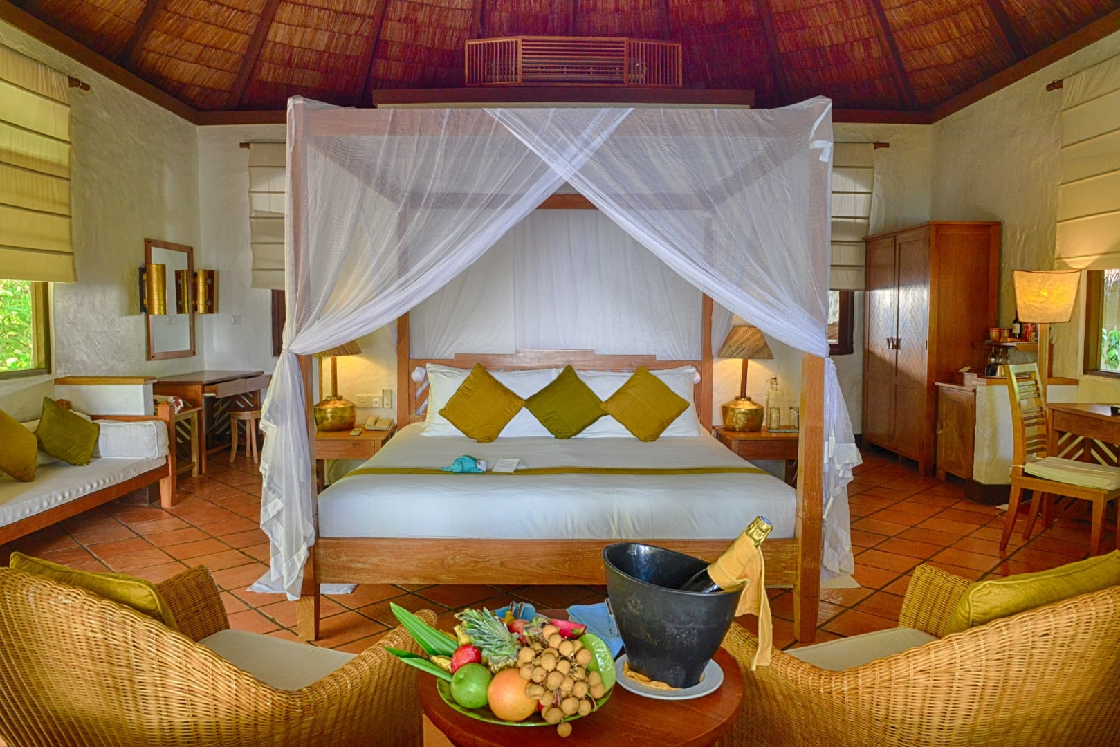 Die geräumigen Schlafzimmer verfügen über eine hohe Spitzdachdecke, ein Kingsize-Bett und Klimaanlage im Coco Palm Dhuni Kolhu Maldives