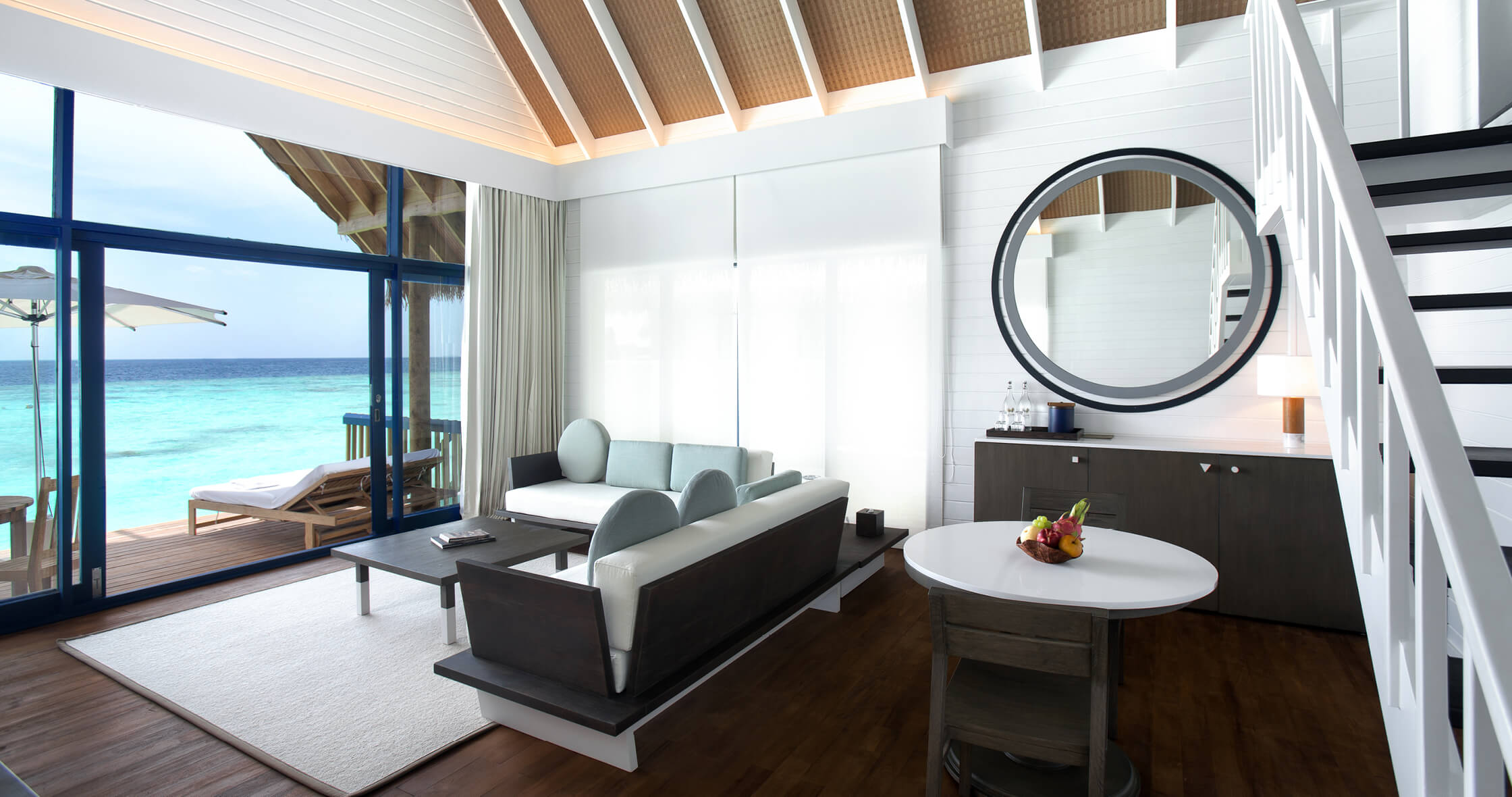 Dhoni Loft Water Villa interior — mezzanine sleeping above the open living area