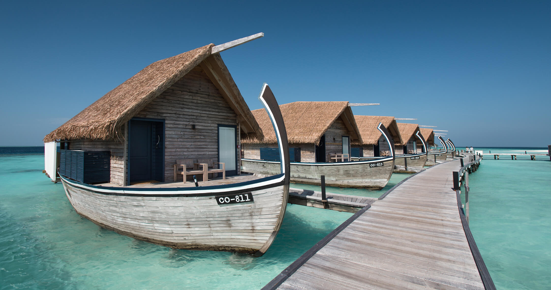Dhoni Water Villas — dhoni-boat silhouettes along the south boardwalk