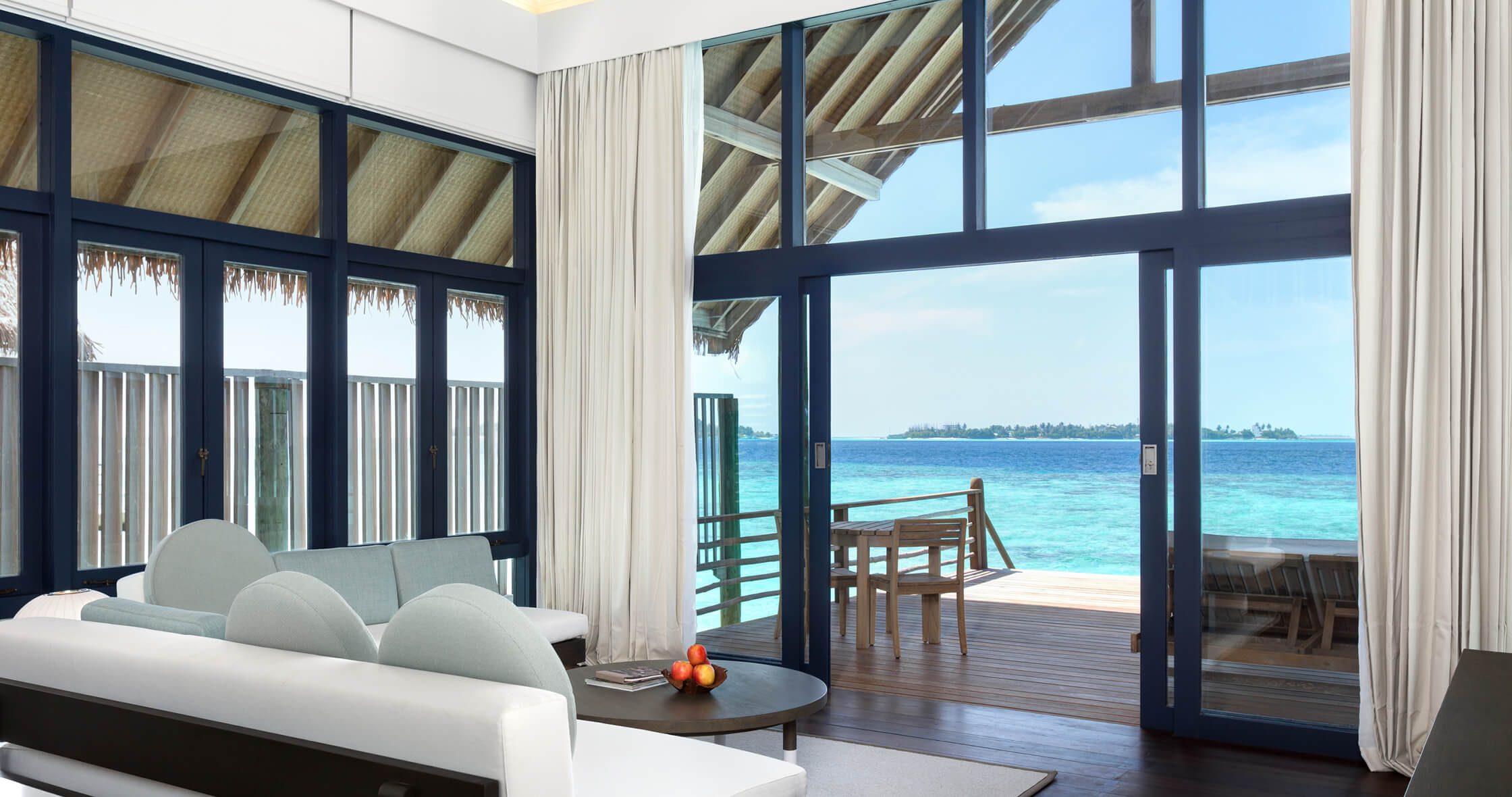 Loft Water Villa interior — floor-to-ceiling lagoon view from the open lounge