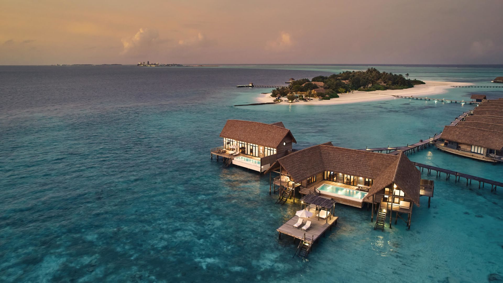 Three-Bedroom COMO Sunset Villa — dusk aerial showing both pool wings