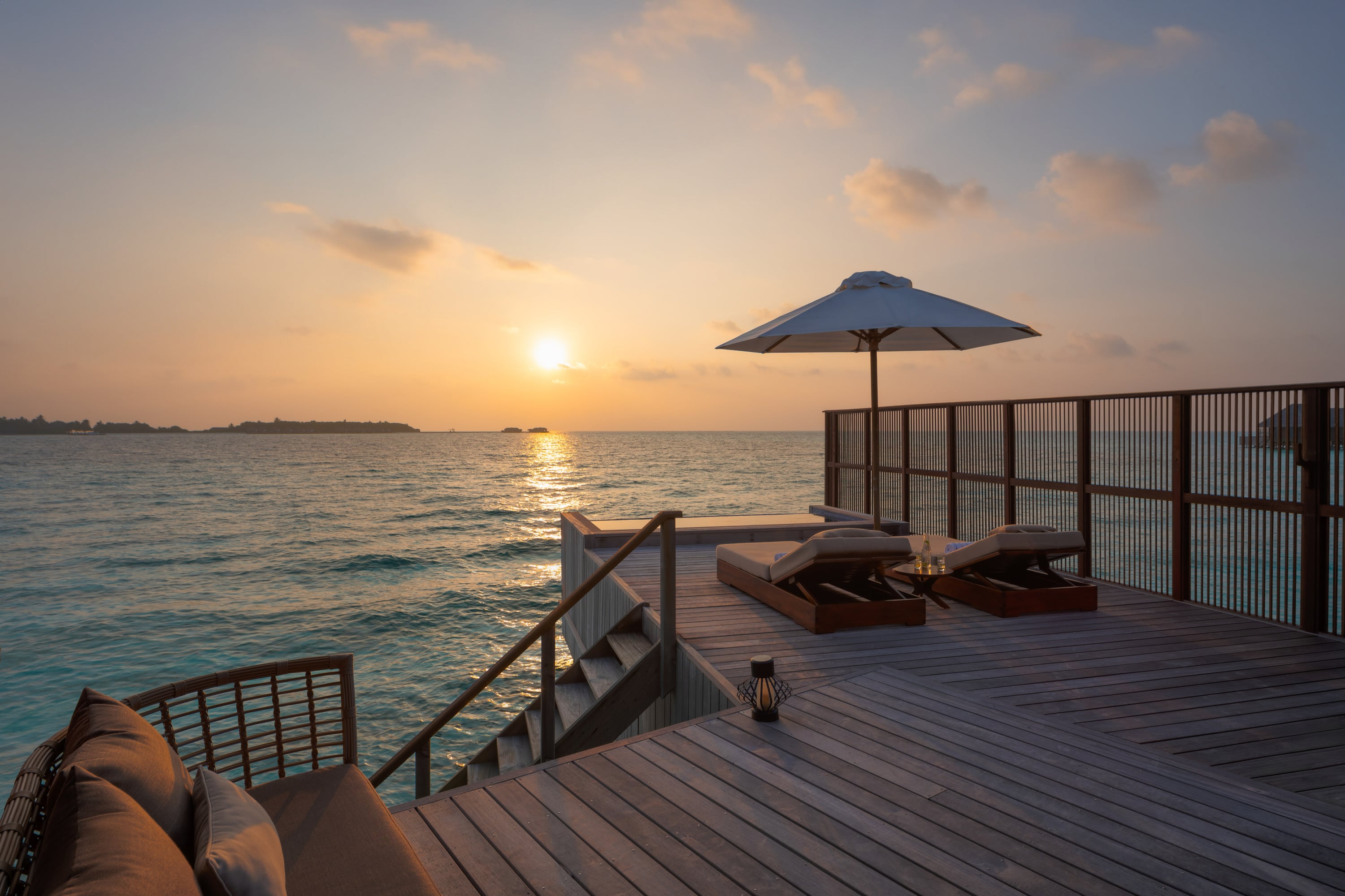 Blick auf die Terrasse mit Sonnenuntergang über dem Horizont im Conrad Maldives Rangali Island