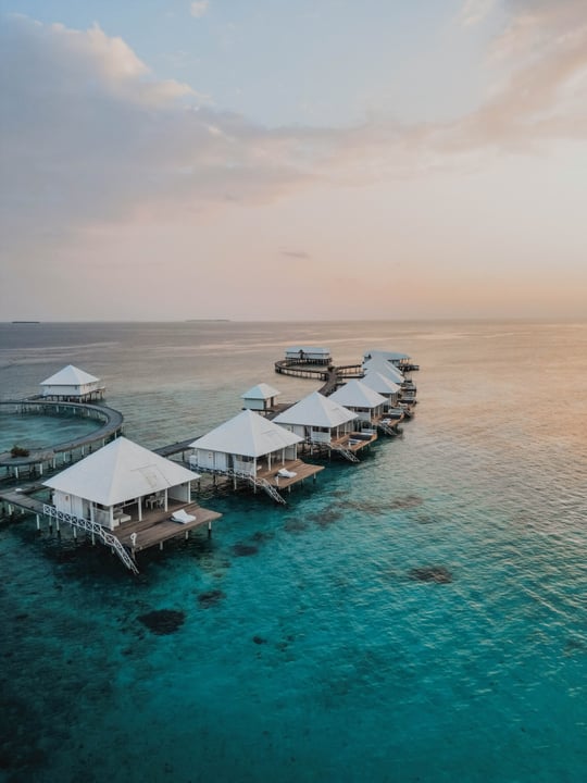 Foto von Diamonds Thudufushi in Diamonds Thudufushi Beach and Water Villas. Könnte ein Bild von Ozean, Dämmerung, Cabana und Text sein.