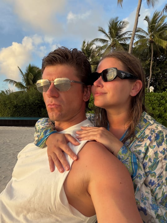 Foto condivisa da Игорь Чехов il 19 settembre 2026 con tag a @juliatopolnitskaya e @sirrufenfushi.maldives. Potrebbe essere un'immagine di persone che si baciano, occhiali da sole, palme e testo.
