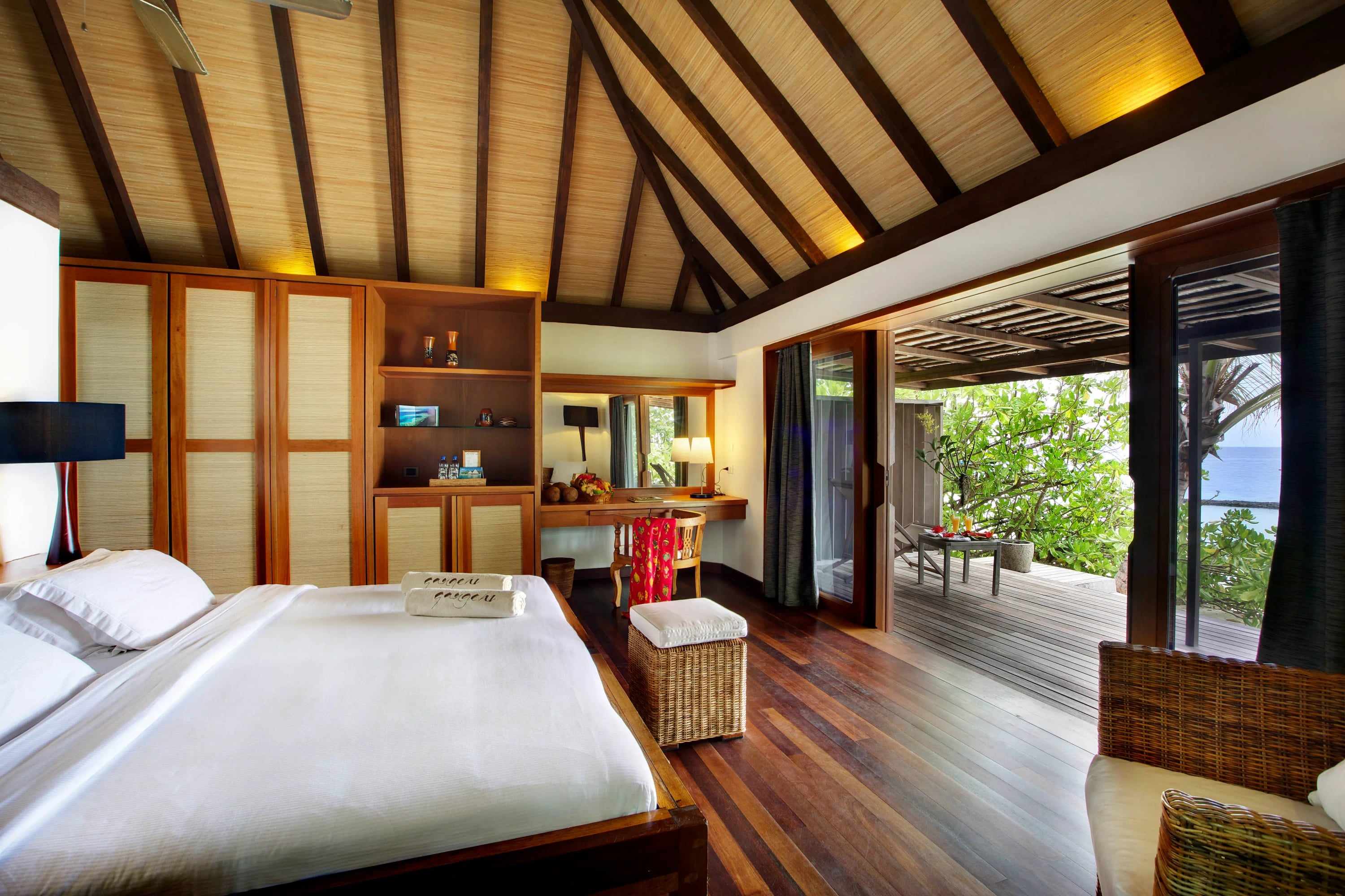 Beach Villa, une chambre au sol en teck ouvrant sur une véranda couverte et la plage à Gangehi Island Resort & Spa