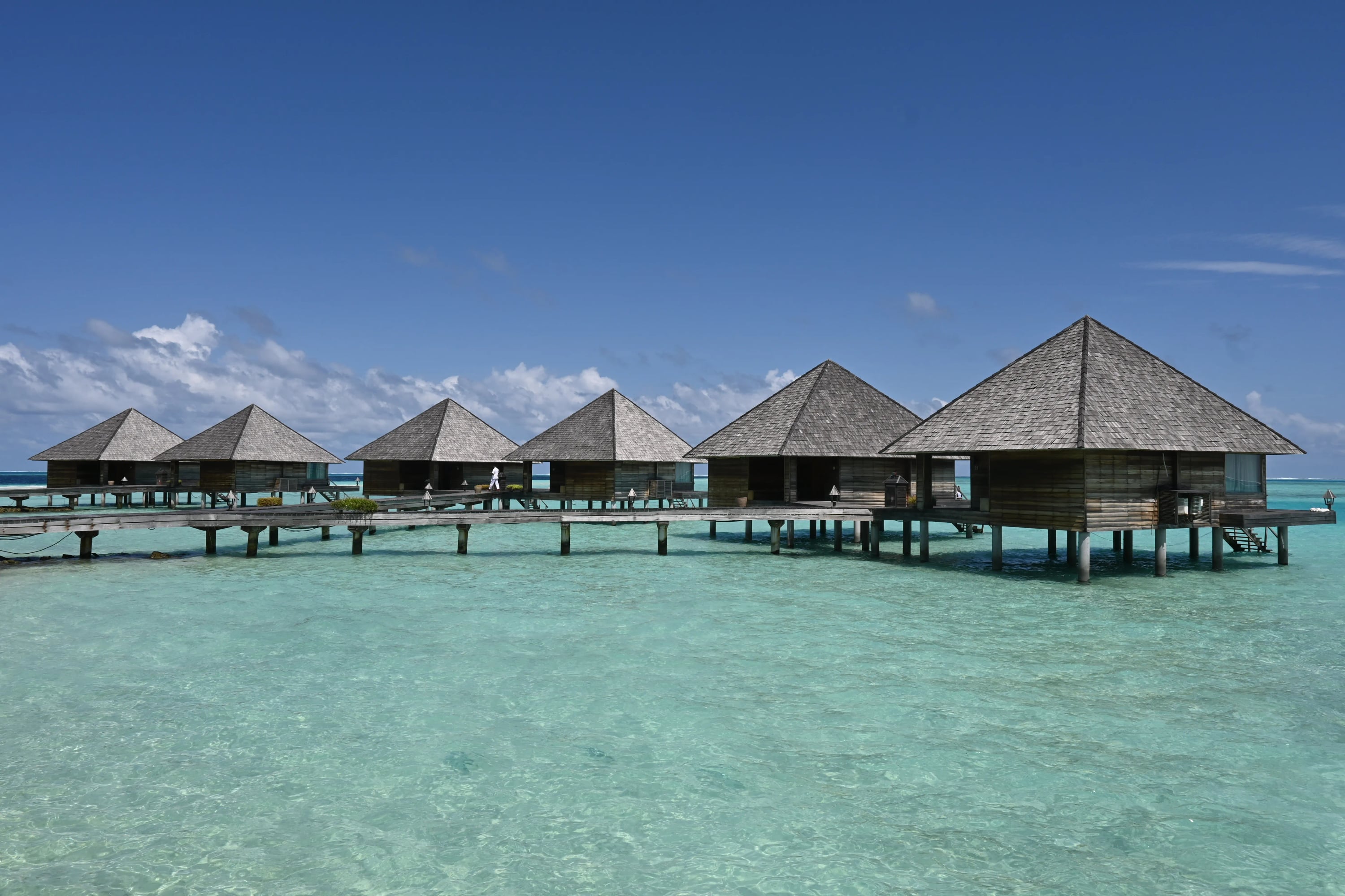 Overwater Villas, une rangée de villas en chaume sur pilotis au-dessus du lagon à Gangehi Island Resort & Spa
