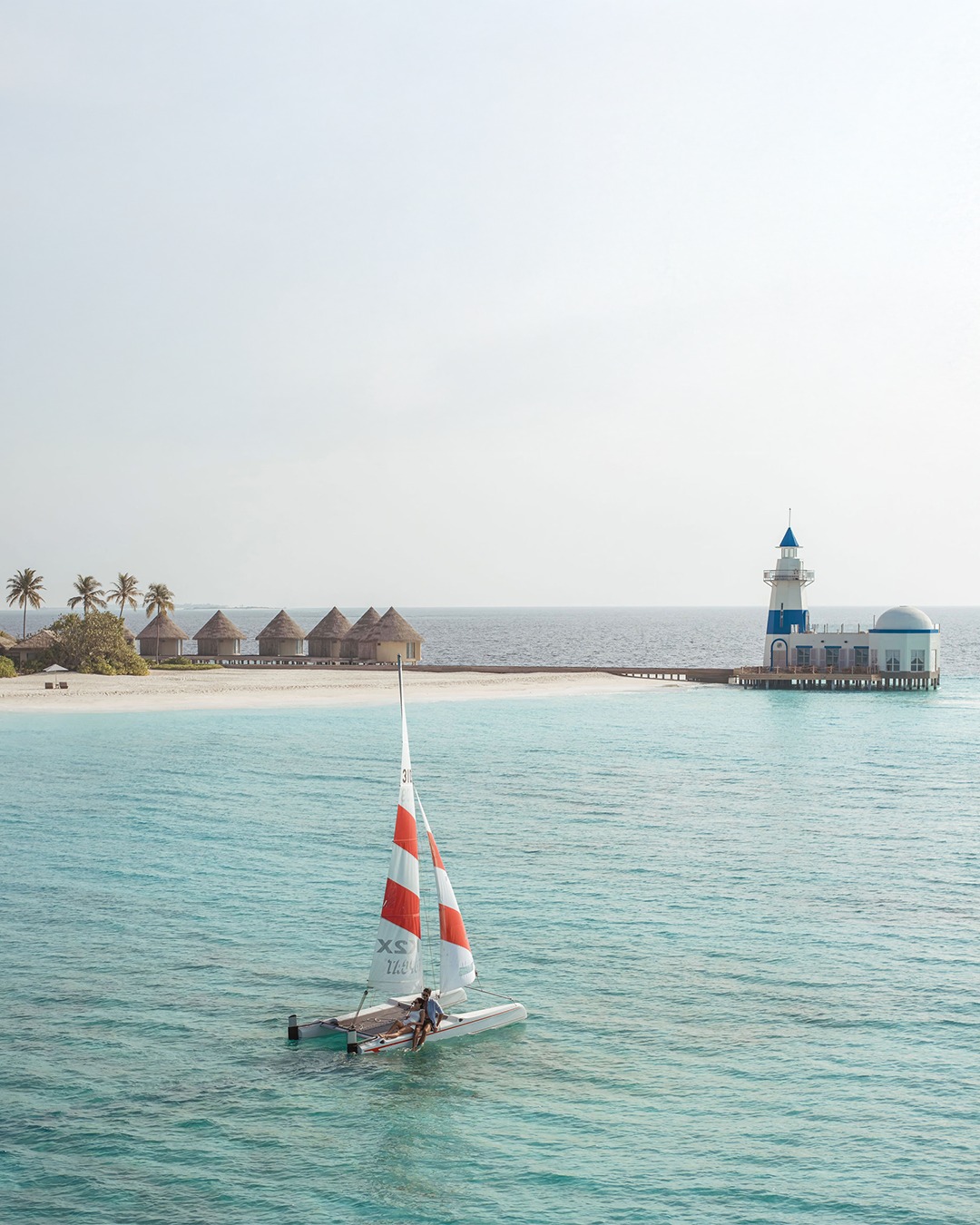Photo by InterContinental Maldives in InterContinental Maldives Maamunagau Resort. May be an image of sailing boat, sail, yacht, ship, speedboat, lighthouse and text.