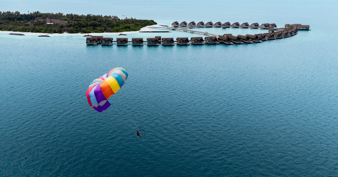 Foto von JOALI BEING in JOALI BEING. Könnte ein Bild von Fallschirmspringen, Parasailing, Fallschirm, Drachen und Text sein.