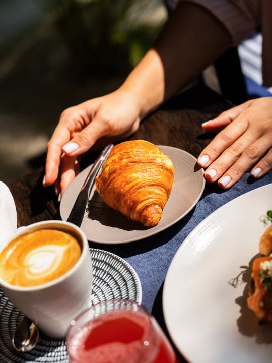 Photo by JOALI Maldives on August 03, 2026. May be an image of baguette, turnover, cappuccino, croissant, tableware and text.