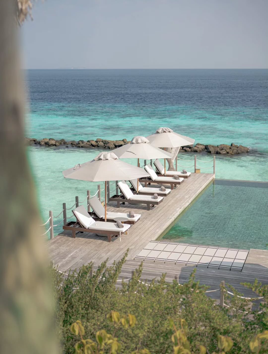 Photo by JW Marriott Maldives Resort & Spa on June 06, 2026. May be an image of chaise longue, deck chair, pool, horizon, cabana and text.