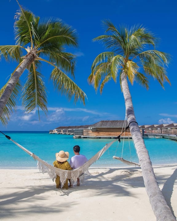 Photo by Kagi Maldives Resort & Spa in Kagi Maldives. May be an image of hammock, deck chair, chaise longue, beach, palm trees, water and text.