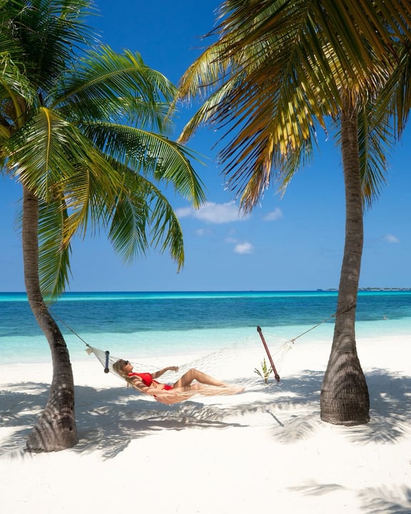 Photo by Kuredu Island Resort & Spa in Kuredu Island Resort. May be an image of hammock, chaise longue, beach, body of water, palm trees and text.