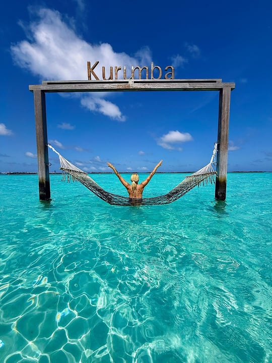 Photo shared by Cinzia Salvini 🌺 Travel Designer 🌺 on June 09, 2026 tagging @nivakurumbamaldives. May be an image of hammock, sarong, ocean, cabana and text that says "Kurumba".