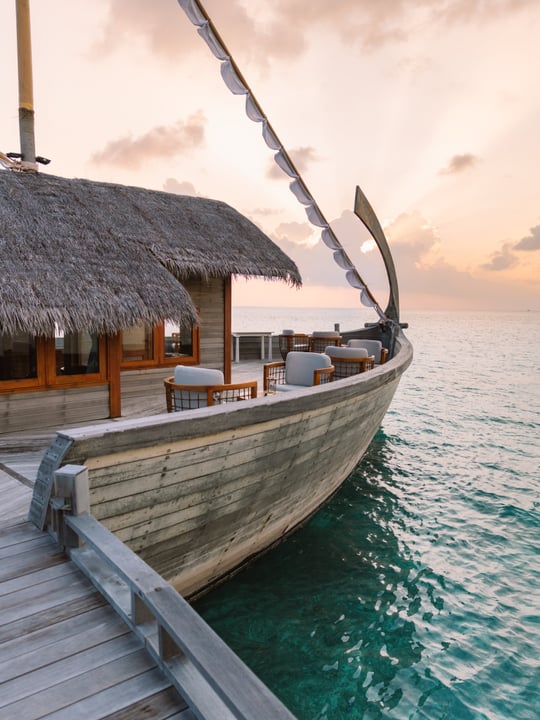 Foto di Milaidhoo Maldives del 12 settembre 2026. Potrebbe essere un'immagine con vela, barca, crepuscolo, acqua, casa galleggiante, rimessa per barche e testo.