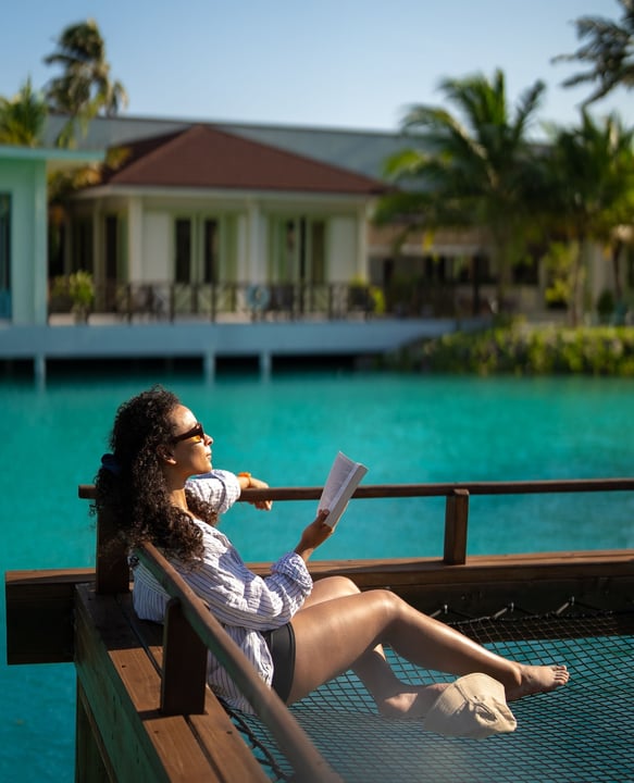 Foto di OBLU XPERIENCE Ailafushi a OBLU Xperience Ailafushi. Potrebbe essere un'immagine di amaca, piscina, cabana e testo.