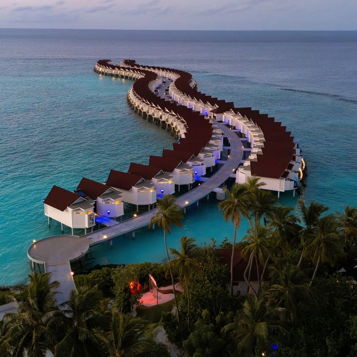 S'étirant dans le lagon turquoise, les Water Villas d'OBLU XPERIENCE Ailafushi créent une évasion insulaire saisissante. À la tombée du soir, les villas s'illuminent sur l'eau, offrant une expérience différen