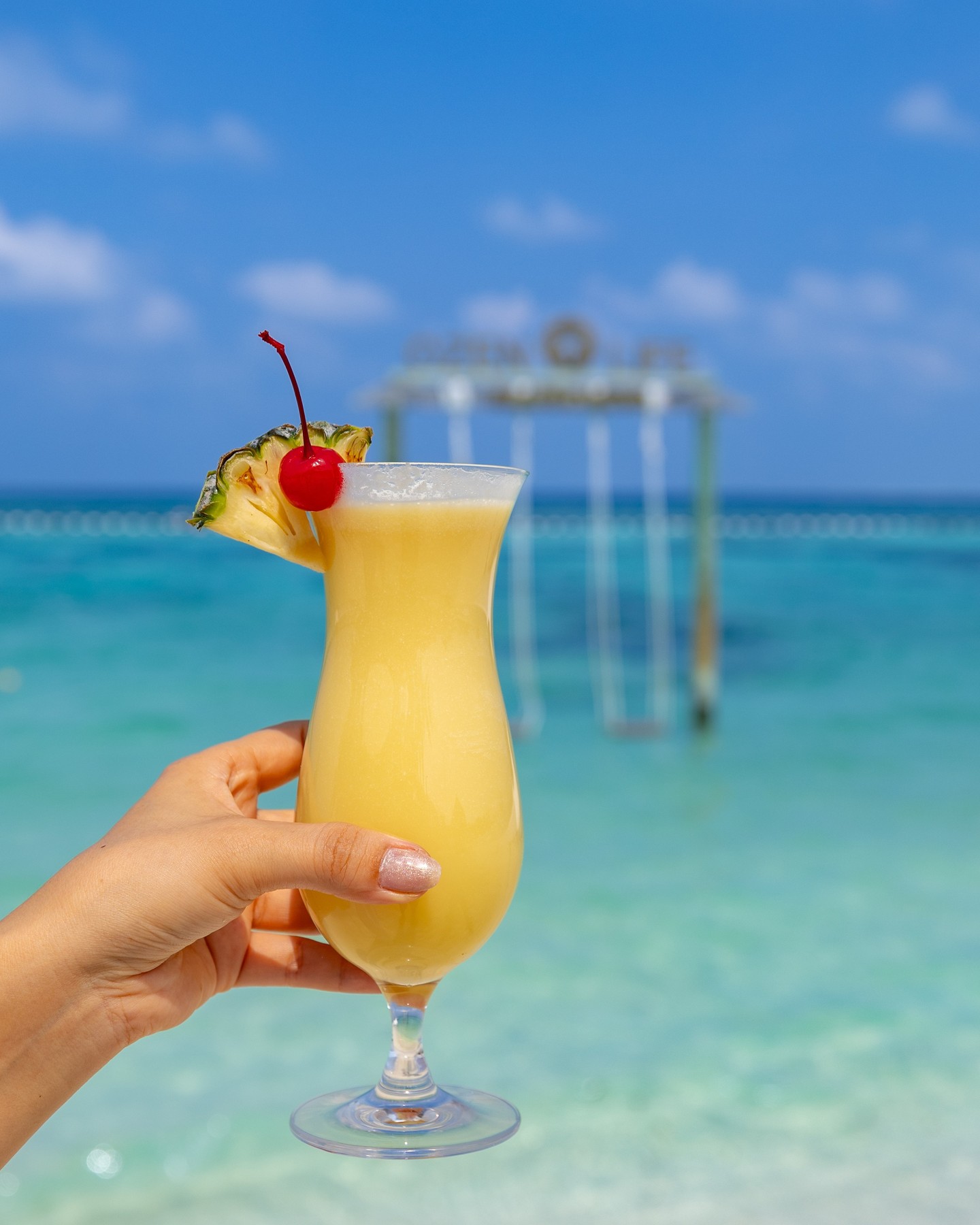 Foto von OZEN LIFE MAADHOO in OZEN LIFE Maadhoo mit @maadhoomaldives. Zu sehen sind möglicherweise ein Cocktail, ein Strand, ein Gewässer, eine Cabana und Text.