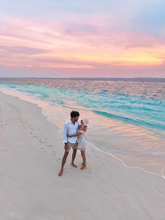 Photo shared by Helen Janneson-Bense on June 18, 2026 tagging @nhcollectionmaldivesreethi. May be an image of one or more people, people kissing, ocean, beach, twilight, wedding and text.