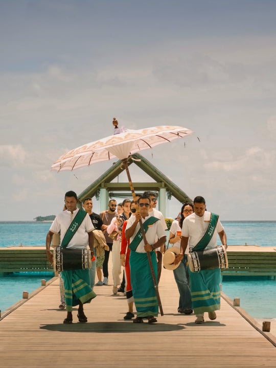 Foto von Iru Veli vom 24. August 2026. Könnte ein Bild von einer oder mehreren Personen, Barong, Sonnenschirm, Schirm, Sarong und Text sein.